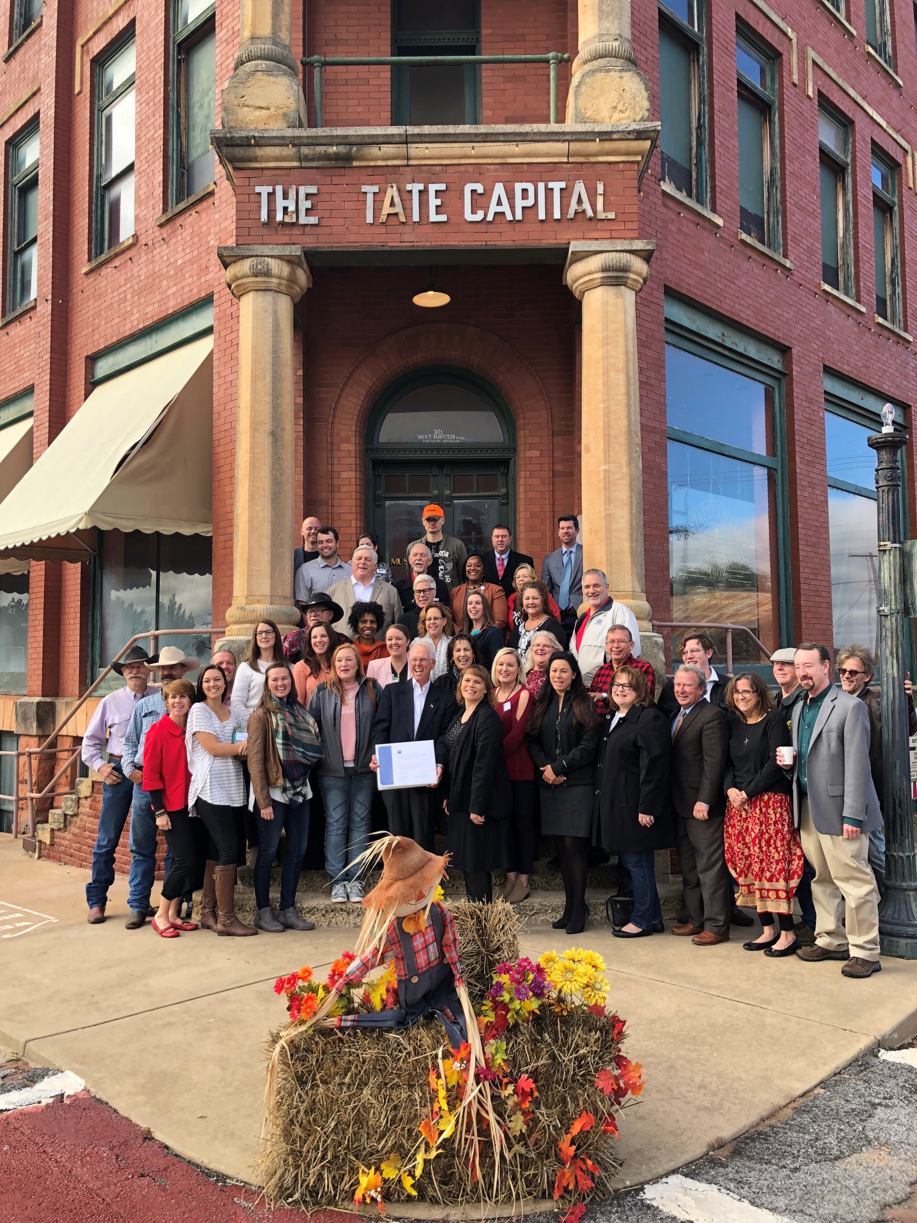 Proud Guthrie citizens and stakeholders gather on the steps of the Publisher's Museum in Guthrie, Oklahoma, to commemorate being named a Great Place in America by the American Planning Association. Pictured on the far right is Mark Sweeney, ACOG Executive Director. 